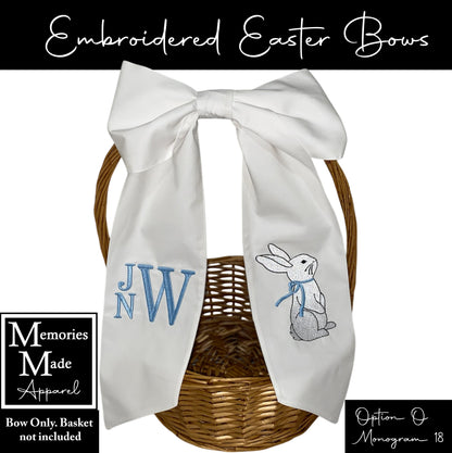 Embroidered Easter bow that is l in color. There is a monogram design on the left side of the bow tail in light blue thread, and a bunny design on the right side. The bunny has a light blue bow. The background of the picture is white, and there is information in the corners. The information states: Bow only, basket not include. It shows that the option to order is "O" and the monogram shown is #18.