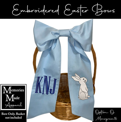 Embroidered Easter bow that is light blue in color. There is a monogram design on the left side of the bow tail, and a bunny design on the right side. The background of the picture is white, and there is information in the corners. The information states: Bow only, basket not include. It shows that the option to order is "O" and the monogram shown is #16.